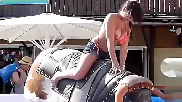 Bikini girl rides mechanical bull outdoors