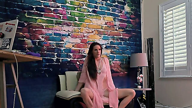 Hippie mature strips down in front of colorful wall in photoshoot