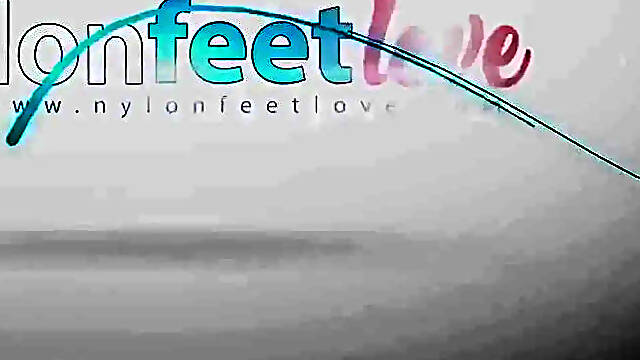 Redhead inked Lauretta loves to play with her feet in stockings