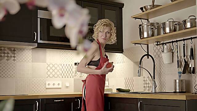Mature blonde Peggy seductively strokes her wet pussy in sheer lacy lingerie